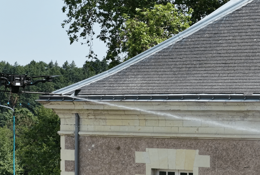 Drone en train de démoussage une toiture en ardoises