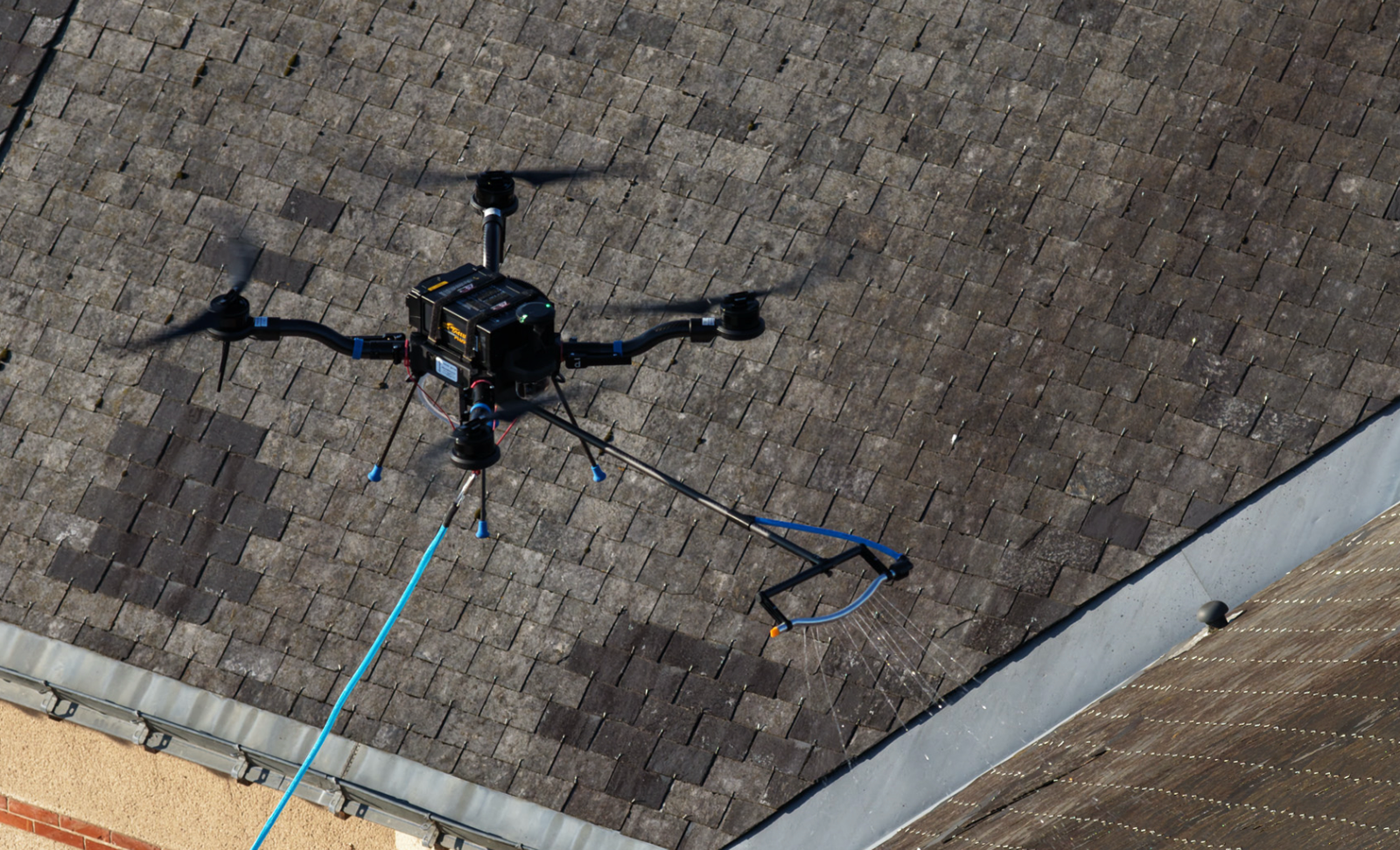 Drone professionnel en train de pulvériser un fongicide sur une toiture