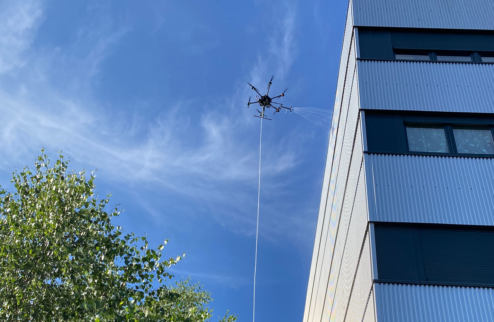 professionnel du bâtiment avec drone de pulvérisation sur chantier